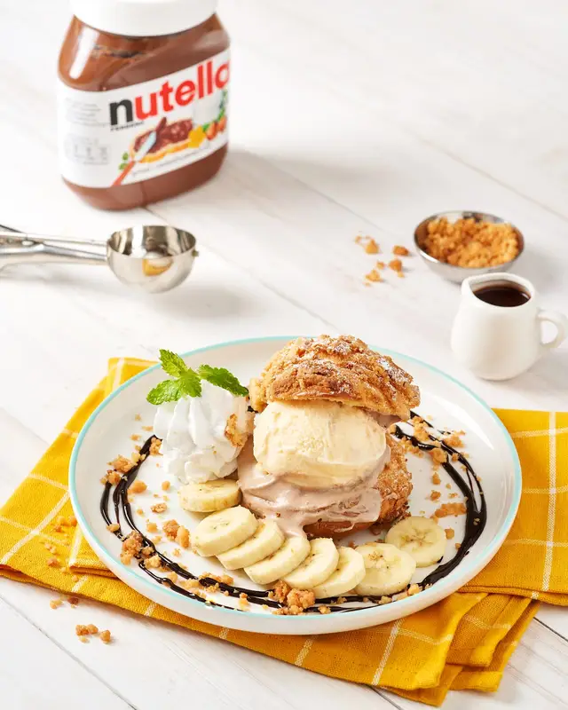 Giant choux cream with ice cream, banana slices and chocolate sauce