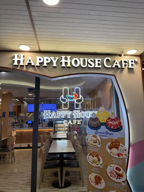Shop front on Banthat Thong Road with a lit Happy House Cafe' sign and a dessert menu stand